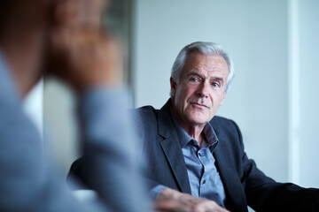 Attentive senior businessman listening in meeting