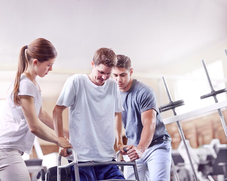 Physical therapists helping man with walker