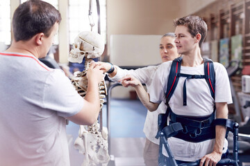 Physical therapist explaining spine model to man