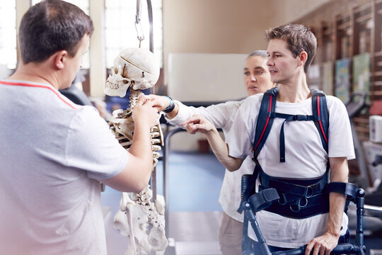 Physical therapist explaining spine model to man