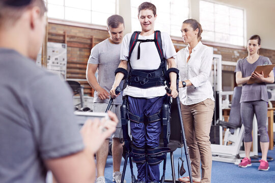 Physical therapists guiding man walking