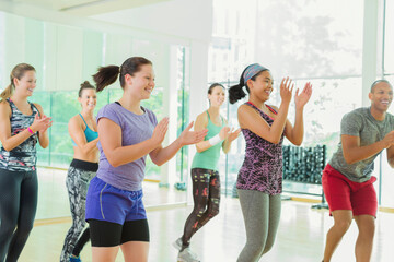 Smiling students clapping in aerobics class