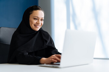 Beautiful arabian woman with abaya dress working in the office