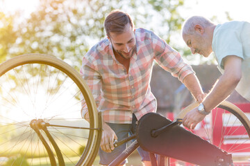 Father and adult son fixing bicycle