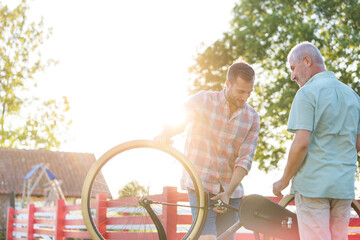 Father and adult son fixing bicycle