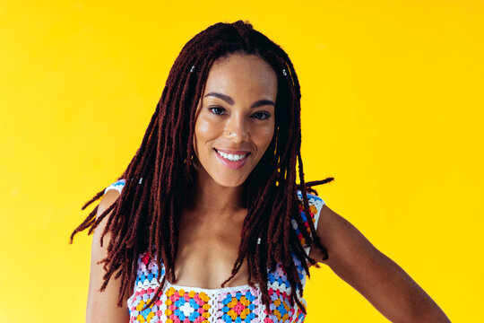 Woman posing on colored backgrounds in studio wearing trendy clothes