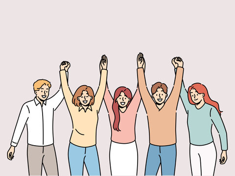 Friendly team holding hands and smiling for concept of successful collaboration to achieve ambitious goals. Team of students or colleagues from men and women rejoice at completion of joint project