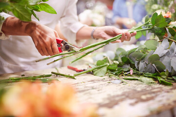 Florist trimming flower stems at flower shop
