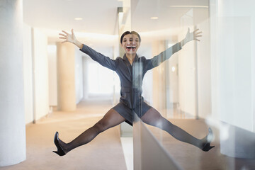 Symmetrical reflection Portrait playful businesswoman arms legs apart in office corridor