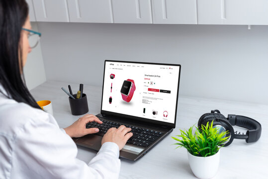 Woman buys a smart watch online. Shopping from home via laptop. Modern ecommerce website interface