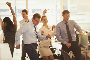 Enthusiastic business people celebrating and dancing in office