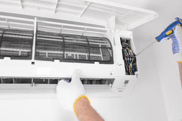 Service guy cleaning and maintaining air condition unit.