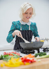 Smiling woman in apron cooking in kitchen