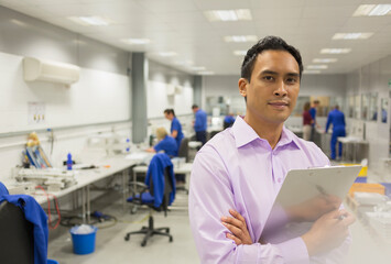 Portrait confident manager with clipboard in steel factory