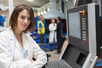 Fototapeta na wymiar Portrait smiling female engineer at control panel in steel factory