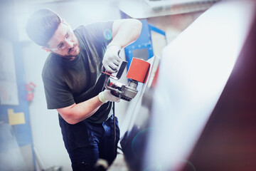 Worker sanding steel in steel factory