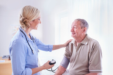 Doctor checking senior man‚Äôs blood pressure in checkup