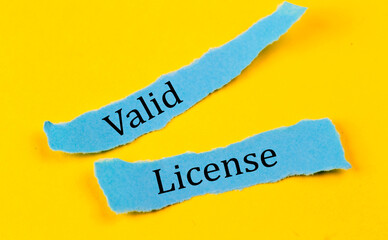 VALID LICENSE text on a blue pieces of paper on yellow background, business concept