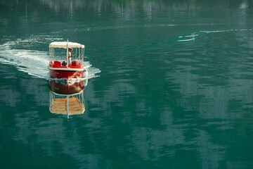 Red boat in the sea floats on azure water 