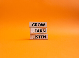 Grow Learn Listen symbol. Concept words Grow Learn Listen on wooden blocks. Beautiful orange background. Business and Grow Learn Listen concept. Copy space