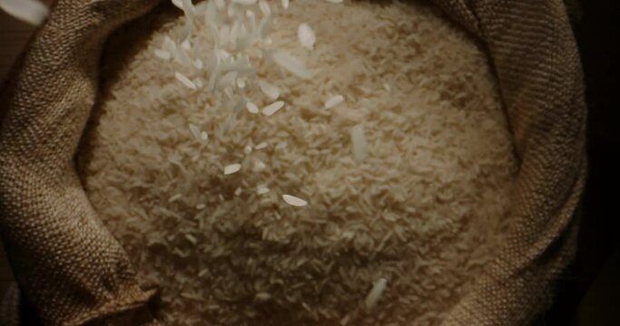 Rice grains fall into an open sack. Top view slow motion camera zoom. Rural development rice production entrepreneurship carbohydrate Natural farming development concept organic food