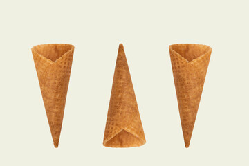 Collection of empty ice cream cone on light beige background.