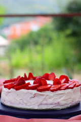 Strawberry and cream sponge cake, served in a garden. Selective focus.