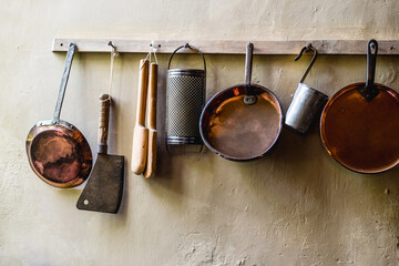 Retro Cooking Utencils Hanging From A Rack In The Kitchen Of An English Historic Manor House