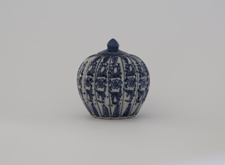 Blue ceramic with a pumpkin-like shape. Blue porcelain white background