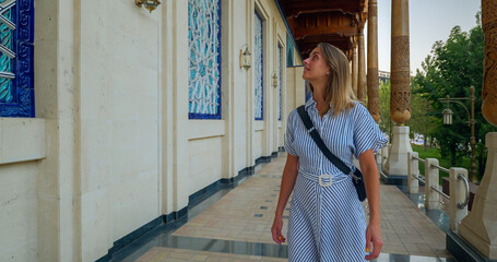 Tourist woman walking and looking to traditonal uzbek ornament