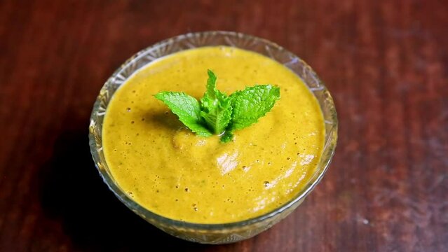 Momo Pickle or chutney served in a glass bowl with mint leaves