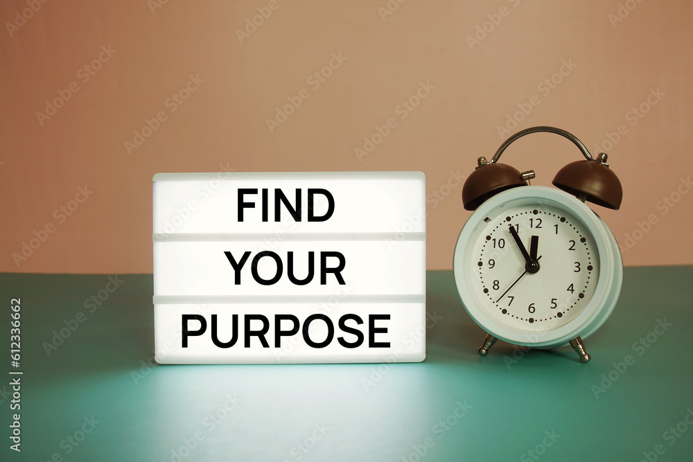 Poster find your purpose text message on paper card with wooden easel and alarm clock