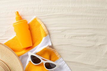 Safe beach tan concept. Top view photo of empty place with straw hat with sunscreen spray, beach towel and sunglasses on the sand on isolated background with copyspace