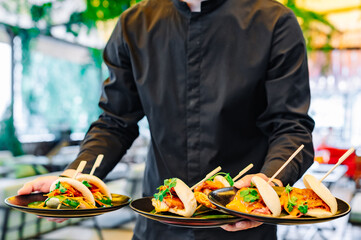 waiter hand hold Gua bao, steamed buns with pork belly and vegetable