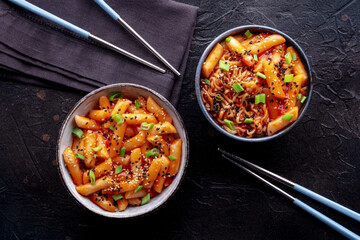 Tteokbokki or topokki and rabokki, Korean street food, spicy rice cakes in red pepper gochujang sauce, overhead flat lay shot