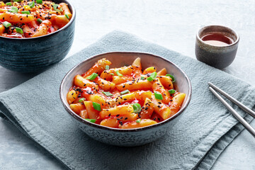 Tteokbokki or topokki and rabokki, Korean street food, spicy rice cakes in red pepper gochujang sauce, a popular dish with a drink