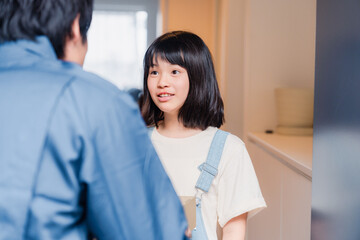 家で宅配便を受け取る小学生の女の子