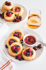 Homemade cottage cheese pancakes with fresh berries on white table