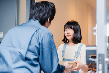 家で宅配便を受け取る小学生の女の子