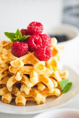 Homemade baked Belgian ricotta waffles with fresh berries on white wooden table