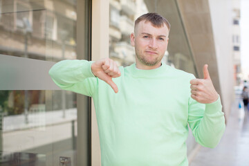 handsome man feeling confused, clueless and unsure, weighting the good and bad in different options...