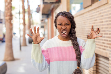 afro pretty black woman screaming in panic or anger, shocked, terrified or furious, with hands next...