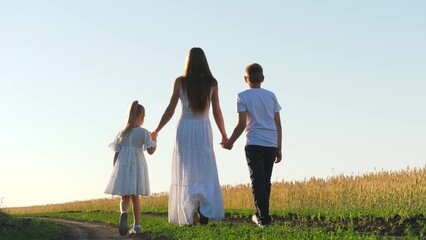 mother child daughter son walk sunset, hold hands. happy family, wheat field, chidhood dream, cheerful people park, woman child park sunset, kid runs, agriculture concept, enthusiastic children
