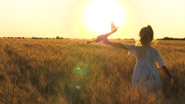 little child girl daughter runs through wheat field with toy plane her hand sunset, happy family dream fly, child runs across field, toy plane, family nature, adventure travel, kid wants become pilot