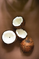 Minimalistic summer composition with ripe coconuts on brown craft background with shadow from...