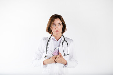 Fototapeta premium Close-up photo of cunning female doctor hiding pack of cash money in her medical gown isolated on white background. Bribe concept