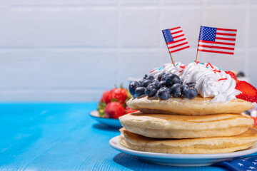 Holiday 4th of July breakfast pancakes, battercakes with whipped cream and berries like american...