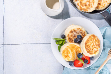 Cottage cheese pancakes, syrniki with fresh berries, sweet summer breakfast. Pan fried roasted portioned cheesecakes 