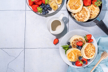 Cottage cheese pancakes, syrniki with fresh berries, sweet summer breakfast. Pan fried roasted portioned cheesecakes 