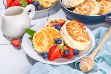 Cottage cheese pancakes, syrniki with fresh berries, sweet summer breakfast. Pan fried roasted...